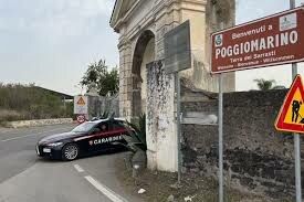 Un'auto dei Carabinieri parcheggiata vicino al cartello stradale di benvenuto a Poggiomarino.